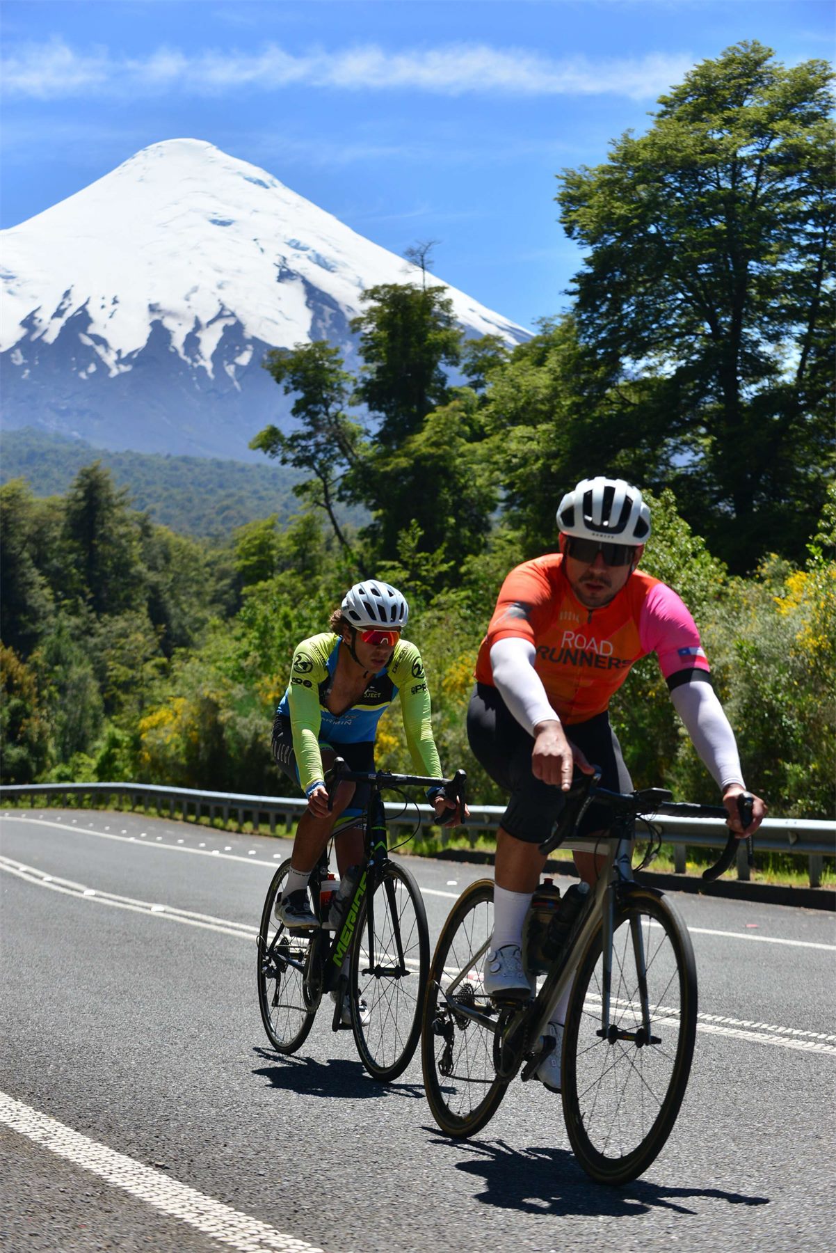 Ciclistas pedaleando con el volcán Osorno de fondo